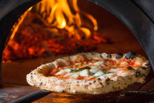 Freshly baked artisan Italian pizza at Tomatoes Pizzeria